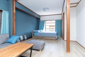 下田市にあるNODE Shimodaのベッドとソファとテーブルのある部屋