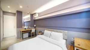 a hotel room with a bed and a desk at NU Hotel in Cheonan