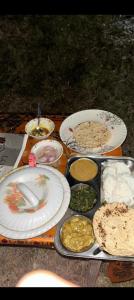 a table topped with plates and bowls of food at Top hill home stay in Sāma +11 photos