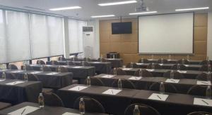 a conference room with tables and chairs and a screen at Jinjiang Metropolo Hotel Classiq Shanghai Off Bund in Shanghai