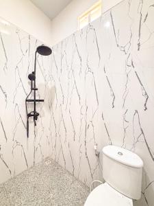 une salle de bain avec toilettes et une lampe au mur dans l'établissement Oemah Maha, à Tanah Lot