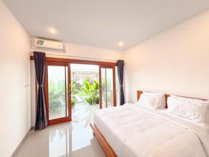 une chambre avec un lit et une grande fenêtre dans l'établissement Oemah Maha, à Tanah Lot