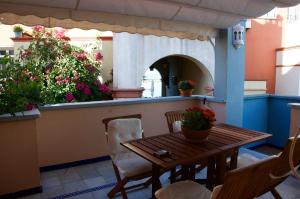 einen Tisch und Stühle auf einem Balkon mit Blumen in der Unterkunft Apartamento Playa Muralla in El Puerto de Santa María
