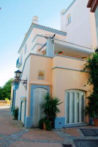 ein weißes Gebäude mit blauen Türen auf einer Straße in der Unterkunft Apartamento Playa Muralla in El Puerto de Santa María