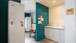 a kitchen with white cabinets and a blue wall at NU Hotel in Cheonan +40 photos