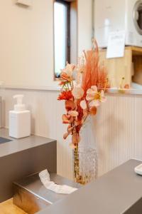 a vase of flowers on a counter in a kitchen at Hakone Villa with your private hot spring! in Hakone +87 photos