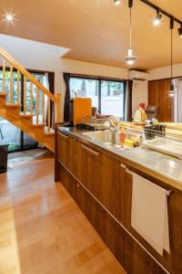 a kitchen with wooden cabinets and a sink at Hakone Villa with your private hot spring! in Hakone