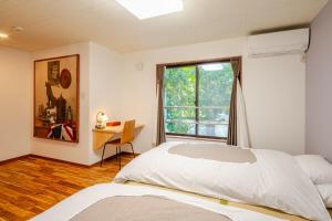a bedroom with a bed and a window and a desk at Hakone Villa with your private hot spring! in Hakone