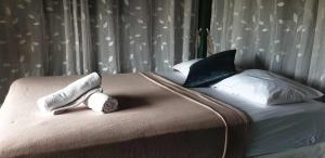 a bed with two towels and pillows on it at The Camping Field in Ban Kluai +2 photos