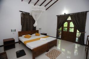 ein Schlafzimmer mit einem Bett und einem großen Fenster in der Unterkunft Scenic Cottage Sigiriya in Sigiriya