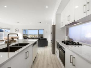 eine weiße Küche mit Spüle und Herd in der Unterkunft Lil Q River Retreat - Aruma River Resort in Walker Flat