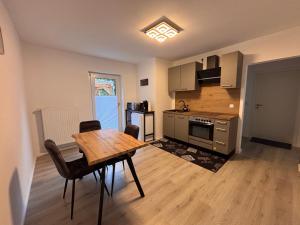 een keuken met een houten tafel en een houten vloer bij Ferienwohnung Daviana in Beckingen