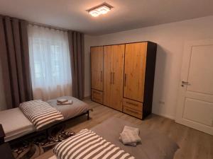 een kamer met 2 bedden en een houten kast bij Ferienwohnung Daviana in Beckingen