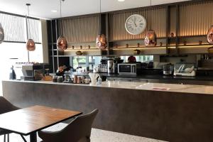 a restaurant with a table and a clock on the wall at The Day Residence in Jakarta