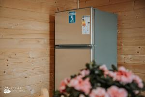 Ein Kühlschrank in der Ecke eines Zimmers mit Blumen in der Unterkunft Chalet Montagne Borzont in Bucsin