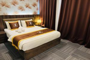 a bedroom with a large bed with brown curtains at Casa Colney Hotel Ipoh in Ipoh