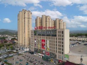 een groot gebouw met een bord erop bij GreenTree Inn Anhui Xuancheng Ningguo NinGYAng East Road Darunfa Branch in Ningguo