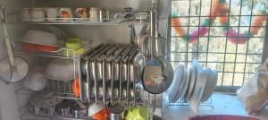 a kitchen with many utensils hanging from a shelf at Top hill home stay in Sāma