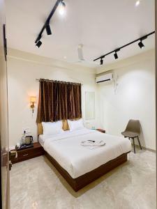 a bedroom with a large bed and a chair at Hotel Riva Inn in Miraj