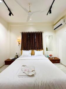 a bedroom with a large white bed with a window at Hotel Riva Inn in Miraj +20 photos