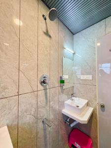 a bathroom with a sink and a shower at Hotel Riva Inn in Miraj