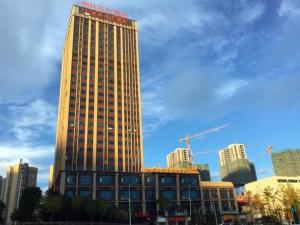 een hoog gebouw met een rood bord erop bij GreenTree Eastern Bijie Qixingguan Zhaoshanghuayuan Hotel in Bijie