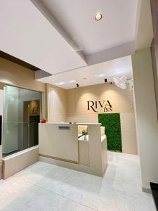 a lobby with a riya tax sign on the wall at Hotel Riva Inn in Miraj