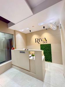 a lobby with a riya inn sign on the wall at Hotel Riva Inn in Miraj +20 photos