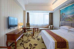 a hotel room with a bed and a desk and a television at Vienna International Shanghai Nanxiang in Chenjiahang +208 photos