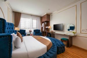a hotel room with a large bed and a television at Royal Hotel & Spa in Ðồng Ky