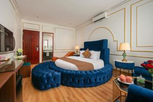 a bedroom with a large bed with a blue chair at Royal Hotel & Spa in Ðồng Ky +7 photos