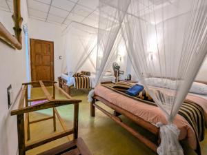 a bedroom with two beds with mosquito nets at New Green View Guest House Kithal Ella in Badulla