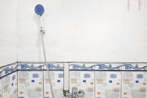a shower in a bathroom with a shower head at RedDoorz Syariah Near Kantor Bupati Jepara in Jepara +27 photos