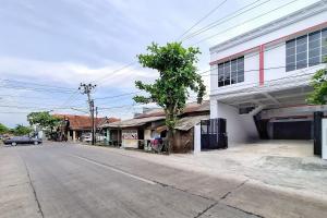 an empty street next to a white building at RedDoorz Syariah Near Kantor Bupati Jepara in Jepara