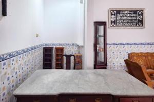 a room with a table and a chalkboard on the wall at RedDoorz Syariah Near Kantor Bupati Jepara in Jepara