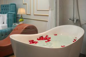 a white bath tub with red flowers on it at Royal Hotel & Spa in Ðồng Ky