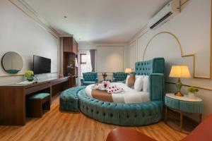 a bedroom with a large bed with a blue ottoman at Royal Hotel & Spa in Ðồng Ky