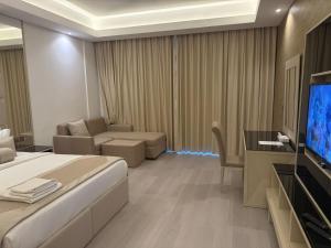 a hotel room with a bed and a couch and a television at Dibba Sea View Hotel by AMA Pro in Dibba +53 photos