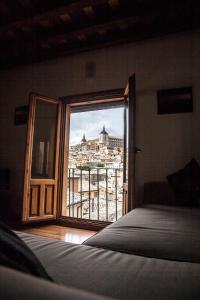 a bedroom with a view of a city from a window at Apartamento Pozo Amargo in Toledo