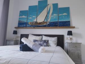 a bedroom with a bed with a painting of a sailboat at La casa del mar Nuimna in Peniscola +56 photos