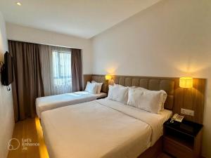 吉隆坡D Loft Hotel的有两张床和一台电视的酒店房间