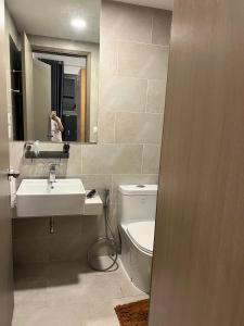 un bagno con lavandino, WC e specchio di mickey home ad Ho Chi Minh