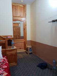 Una habitación con un dormitorio con una cama y un espejo. en Moon Rise Hotel, en Dargai 2 fotos más