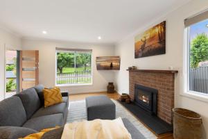 ein Wohnzimmer mit Couch und Kamin in der Unterkunft Lemon & Myrtle Cottage in Myrtleford