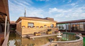 a house with a pond in front of it at GreenTree Inn Nanjing Software Valley DaDingFang Express Hotel in Nanjing