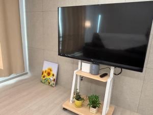 a large flat screen tv sitting on a stand at Indeogwon stay 27 in Mabun-ni