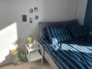 a bedroom with a bed with blue sheets and a table at Indeogwon stay 27 in Mabun-ni +9 photos
