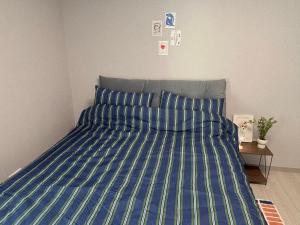 a bed with a blue and green comforter in a bedroom at Indeogwon stay 27 in Mabun-ni