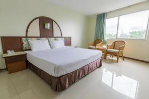 a bedroom with a large bed and a table and chairs at Lake Inn Hotel in Songkhla +104 photos