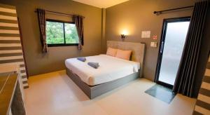 a bedroom with a bed and a large window at The Rest Hotel in Ko Larn